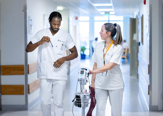 To sykepleiere går i en sykehuskorridor